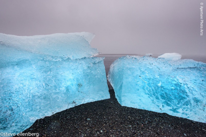 Jökulsárlón. Cracked iceberg on black sand beach at glacial river lagoon
