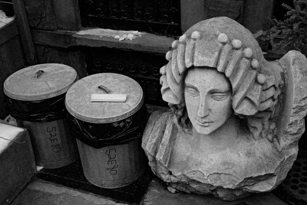 Trash and statue bust, NYC, street photography