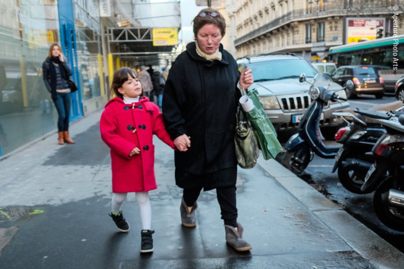 Little girl in a red coat with her grandmother. Paris, France