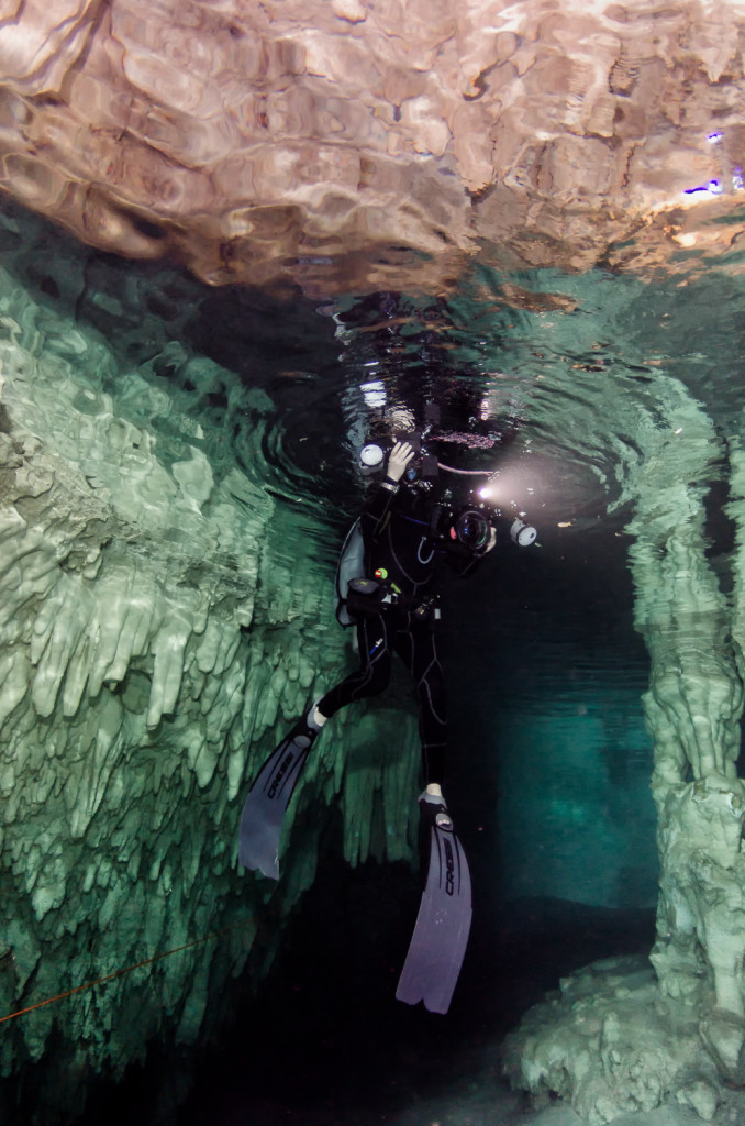 Diver in cenote, with stalagtites