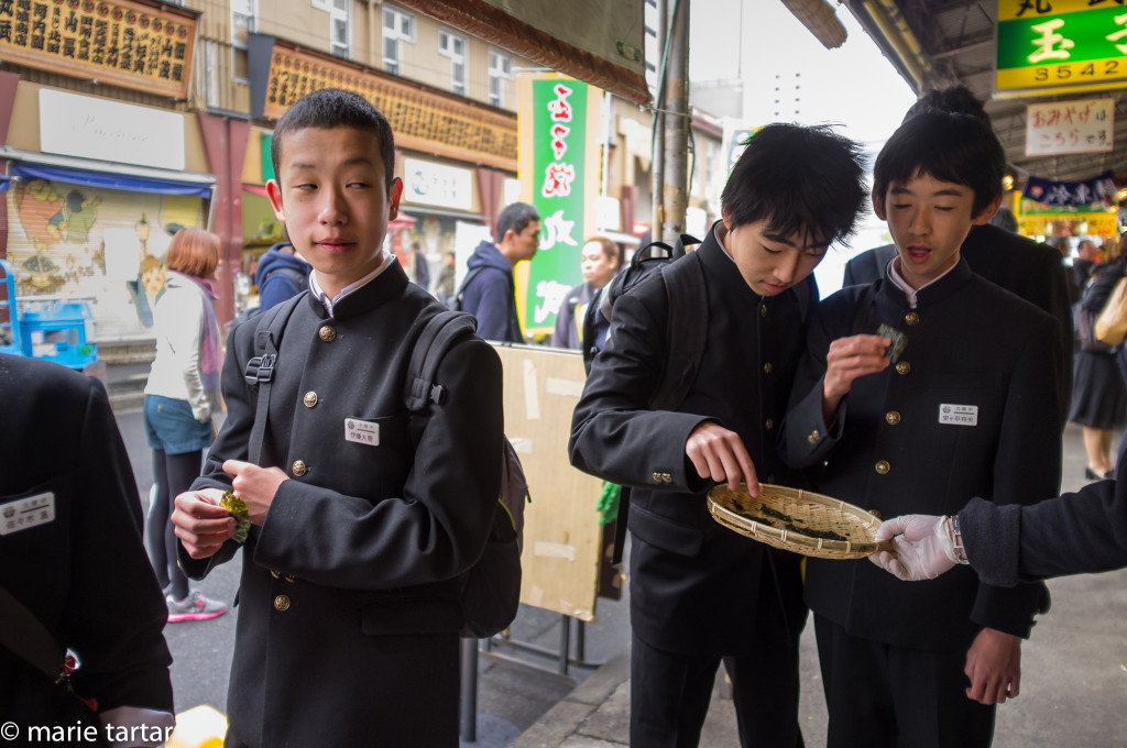 Japanese schoolboys dive into samples in Tsukiji outer market stall, Tokyo