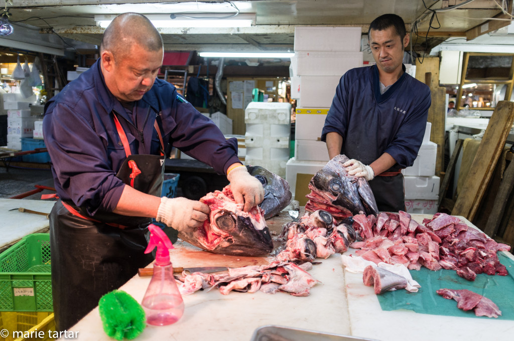 Workers extract all the salvagable meat from fishheads at Tsikiji market in Tokyo
