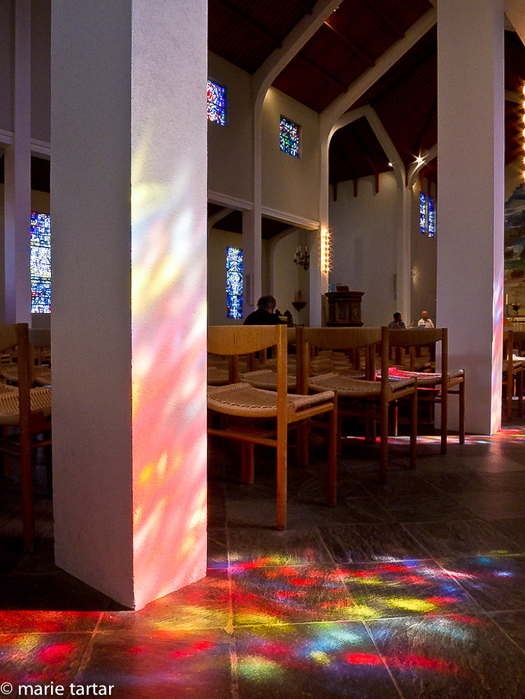 Skaholt church interior with stained glass reflections