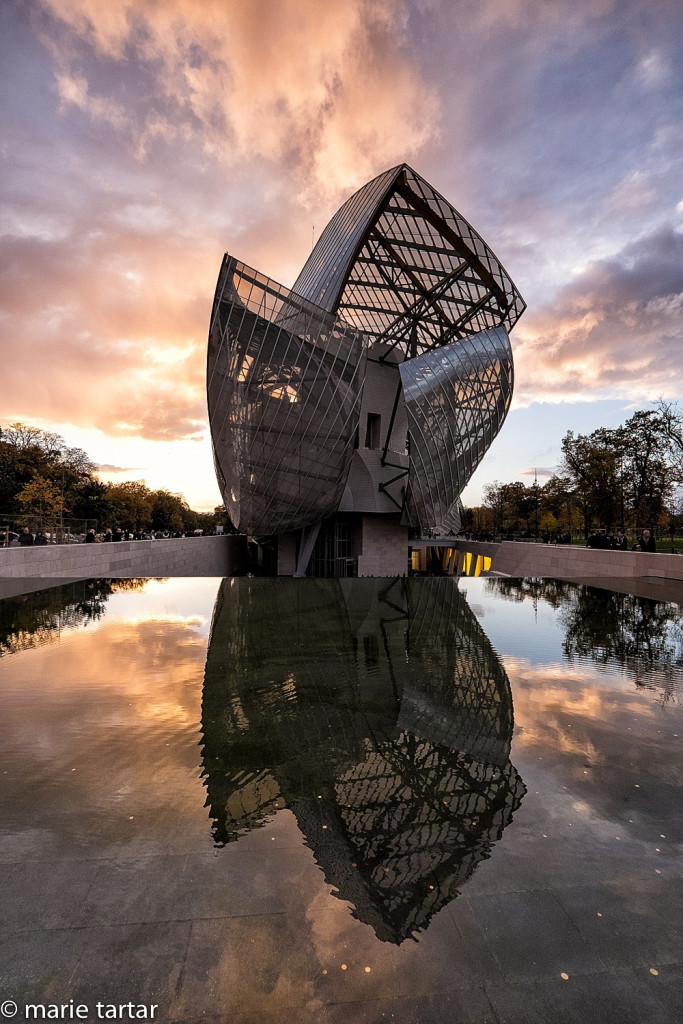 Fondation Louis Vuitton by Frank Gehry, with its long water feature, set off by a nice sunset 