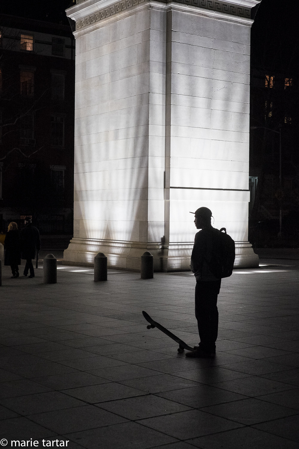 Skateboarder in Washington Square at night