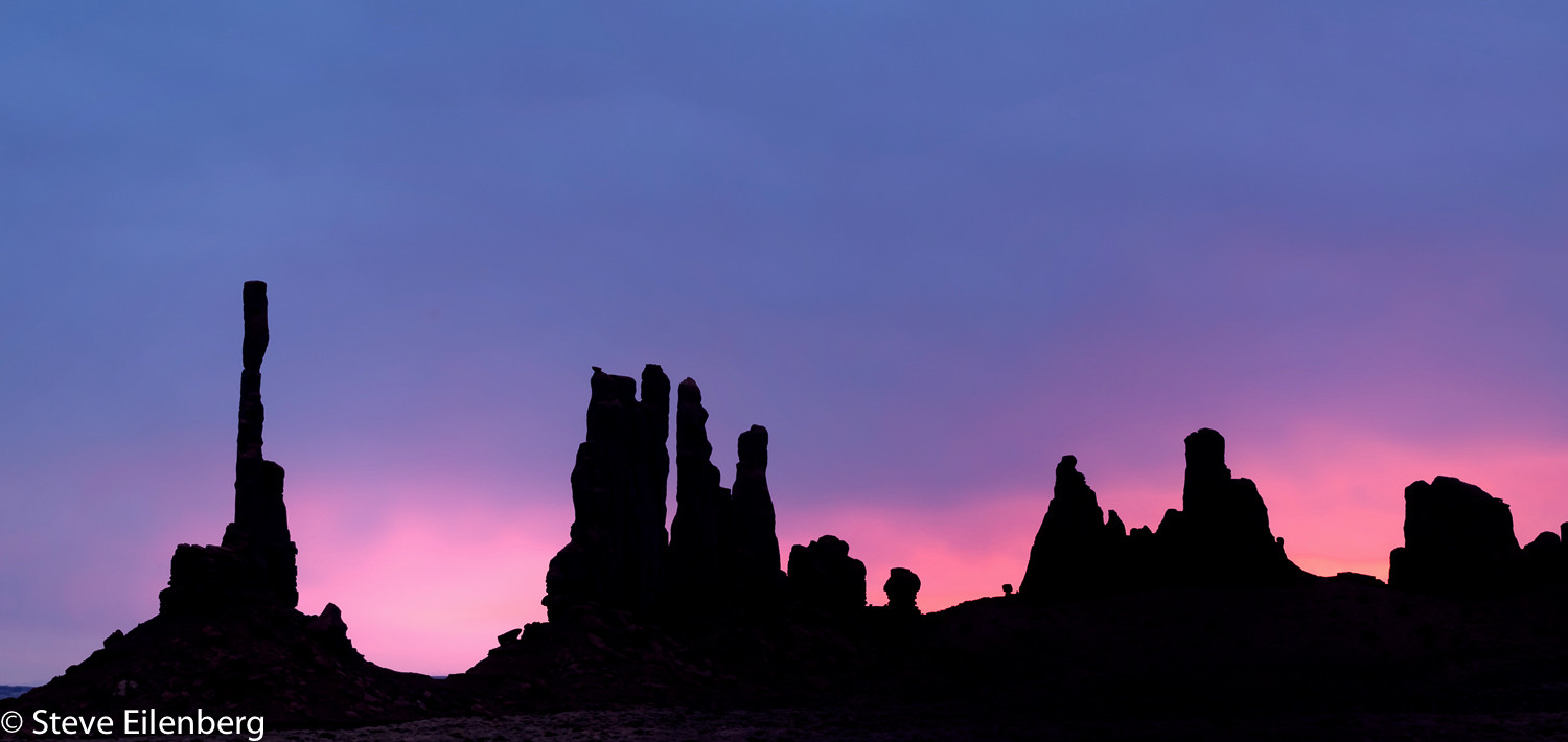 Monument Valley totem formations silhouetted at sunrise