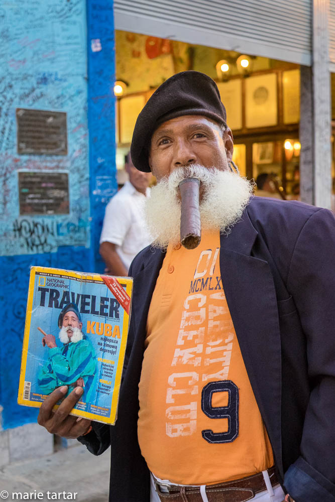 Photogenic bearded Havanite with cigar in front of famed Hemingway favorite bar, La Bodeguito del Medio