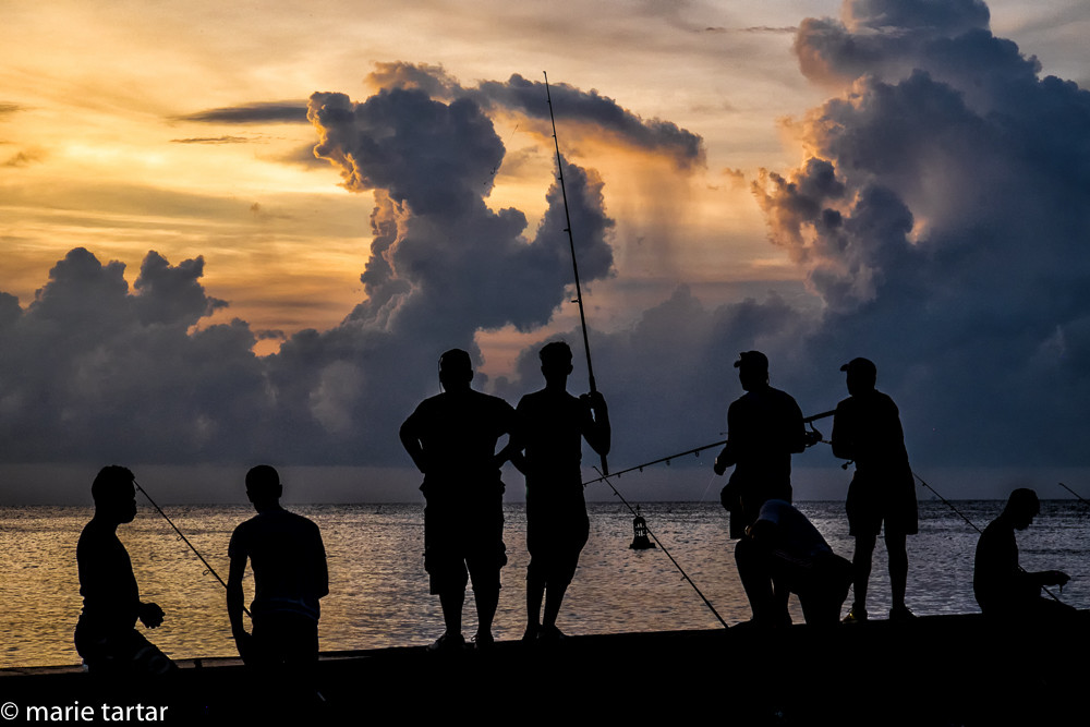 Fishermen cast off the Malecón in Havana