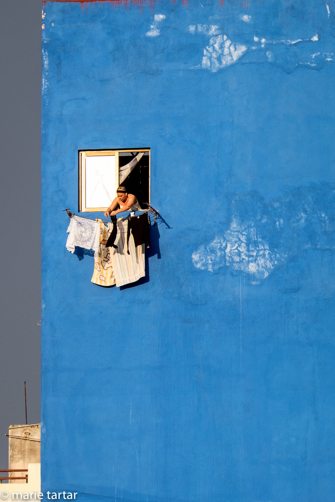Woman hanging laundry out to dry on the Prado in Havana