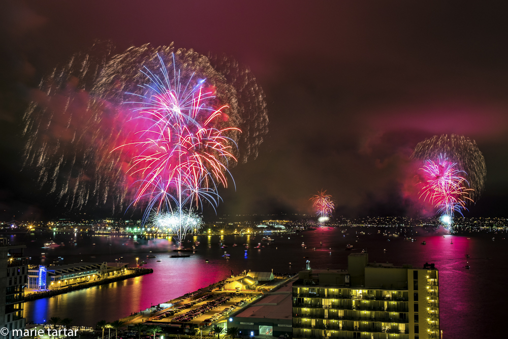 Simultaneous 4th of July fireworks in San Diego Bay, from a downtown highrise vantage