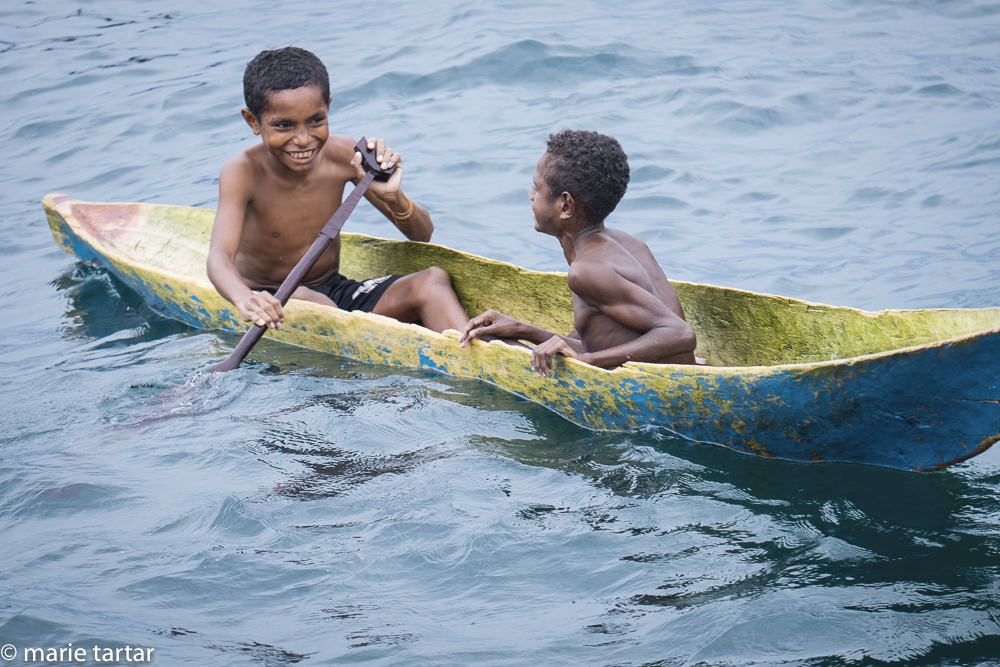 Papuan boys in digout canoe in Triton Bay