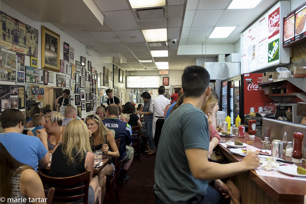 You don't go to Schwatrz's for the decor, but for the smoked meat sandwiches, served to hungry crowds since 1928! Note the acolades crowding the wall to the left and the elbow-to-elbow satisfied customers.